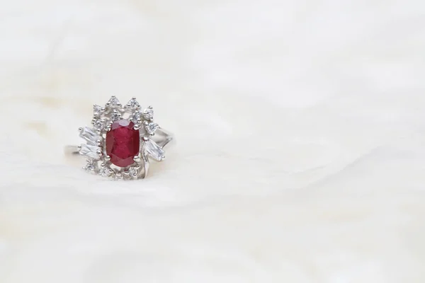 red gemstone on diamond ring