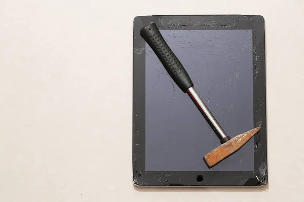 Vidrio plano roto de tableta y martillo oxidado — Foto de Stock
