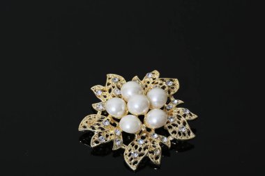 Altın çiçekli ve incili broş.