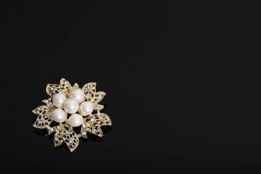 Altın çiçekli ve incili broş.