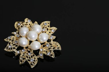 Altın çiçekli ve incili broş.
