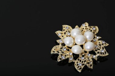 Altın çiçekli ve incili broş.