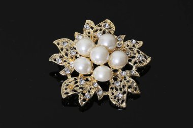Altın çiçekli ve incili broş.