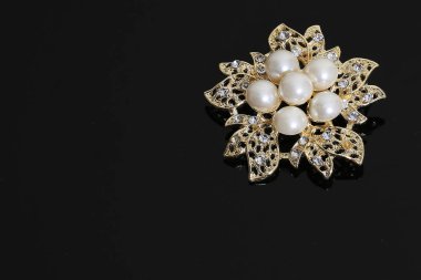 Altın çiçekli ve incili broş.