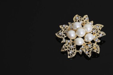 Altın çiçekli ve incili broş.