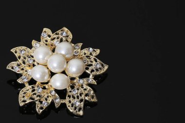 Altın çiçekli ve incili broş.