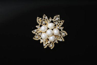 Altın çiçekli ve incili broş.