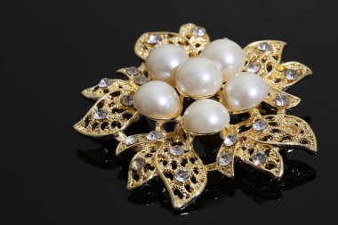 Altın çiçekli ve incili broş.