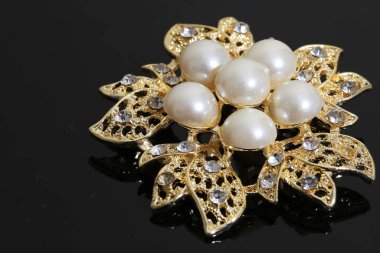 Altın çiçekli ve incili broş.