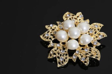 Altın çiçekli ve incili broş.