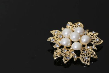 Altın çiçekli ve incili broş.
