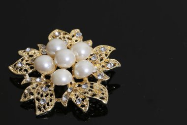 Altın çiçekli ve incili broş.