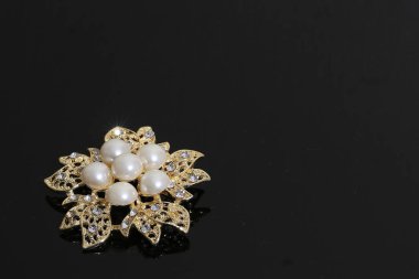 Altın çiçekli ve incili broş.