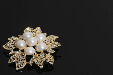 Altın çiçekli ve incili broş.