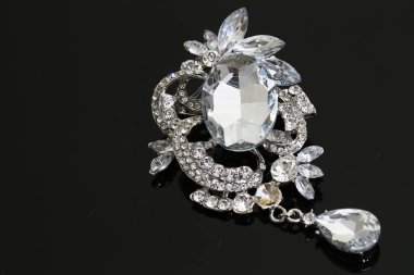 Gümüş çiçekli ve mücevherli bir broş.