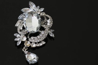 Gümüş çiçekli ve mücevherli bir broş.