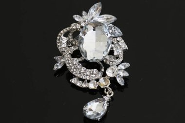 Gümüş çiçekli ve mücevherli bir broş.