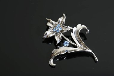 Gümüş çiçekli ve mücevherli bir broş.