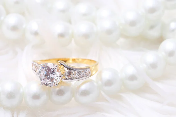 Golden ring with diamond and pearl Stockbild