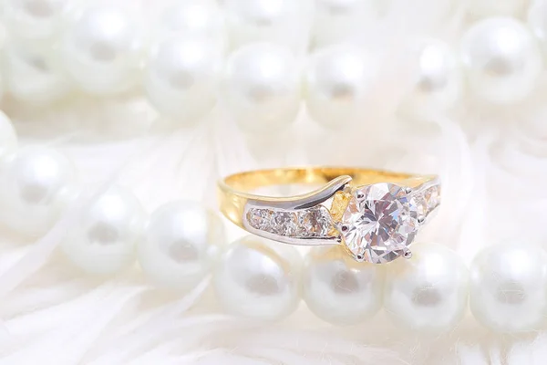 Golden ring with diamond and pearl Stockbild