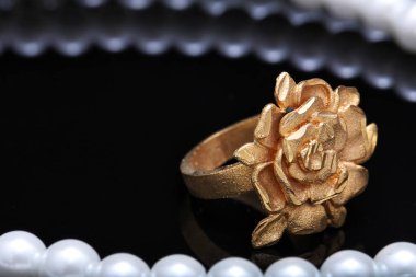 Altın gül yüzüğü ve inci.