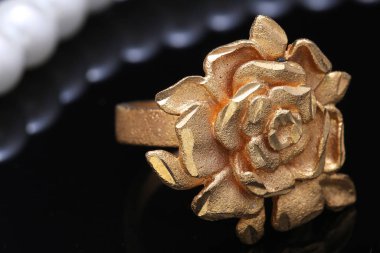 Altın gül yüzüğü ve inci.