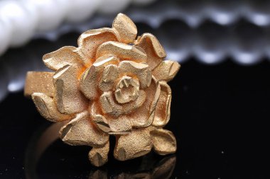 Altın gül yüzüğü ve inci.