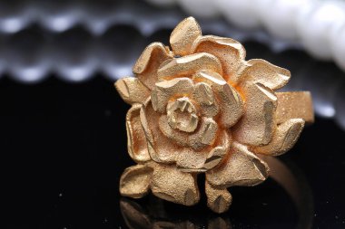 Altın gül yüzüğü ve inci.