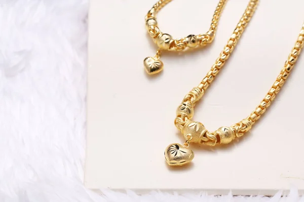 Pingente de coração dourado, laço do pescoço, pulseira de ouro — Fotografia de Stock