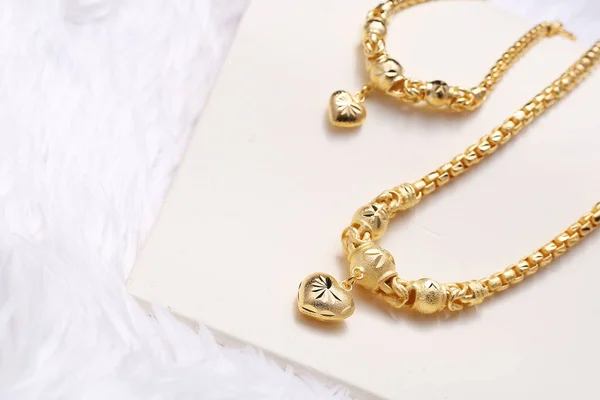 Pingente de coração dourado, laço do pescoço, pulseira de ouro — Fotografia de Stock