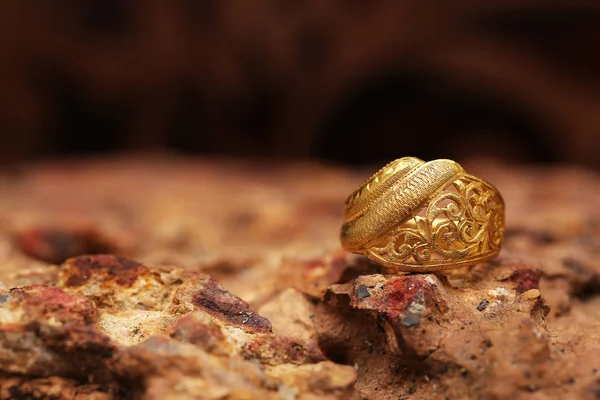 Old golden ring on stone texture — Stock Photo, Image