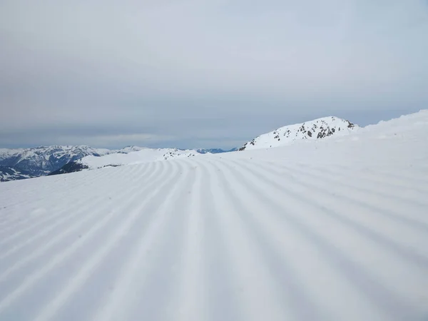 Schnee Aus Nächster Nähe Skihang Vor Dem Hintergrund Schneebedeckter Berggipfel — Stockfoto