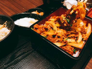 Japon geleneksel çanak Gyudon ince yapılan pirinç çorbası ile sığır eti, soğan, soya sosu dilimlenmiş. Koyu tonu. çubuk kullanarak.