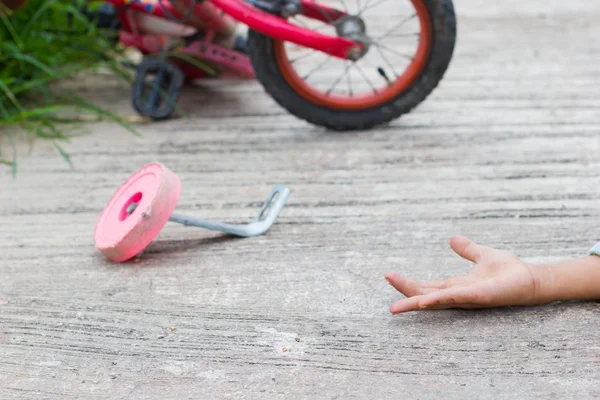 Horizontale foto van close-up fiets voor kinderen ongeval op de stadsstraat met de hand van een kind op de grond — Stockfoto