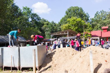 Lampang, Thailand - 5 Kasım: 5 Kasım 2016 yılında Lampang, Thailand plaza yapmak tanımlanamayan Tay gençler beton karıştırma için su taşıyan doğrultusunda çalışma kampında.
