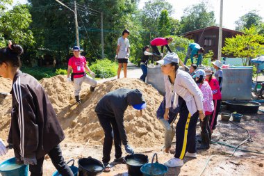 Lampang, Thailand - 5 Kasım: 5 Kasım 2016 yılında Lampang, Thailand plaza yapmak tanımlanamayan Tay gençler beton karıştırma için su taşıyan doğrultusunda çalışma kampında.