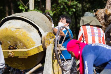 Lampang, Thailand - 5 Kasım: tanımlanamayan Tay gençler çalışma kampında beton mikser makine ile karıştırma üzerinde 5 Kasım 2016 yılında Lampang, Thailand.