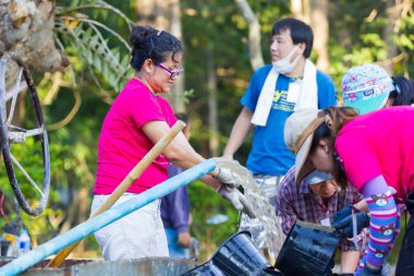 Lampang, Thailand - 5 Kasım: 5 Kasım 2016 yılında Lampang, Thailand plaza yapmak tanımlanamayan Tay gençler beton karıştırma için su taşıyan çalışma kampında.