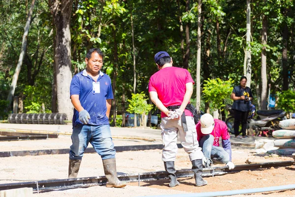 LAMPANG, THAILANDIA - 5 NOVEMBRE: adolescenti thailandesi non identificati nel campo di lavoro preparano l'area per versare cemento per fare piazza il 5 novembre 2016 a Lampang, Thailandia . — Foto Stock
