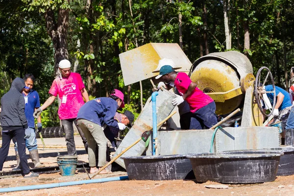 LAMPANG, THAÏLANDE - 5 NOVEMBRE : Des adolescents thaïs non identifiés dans un camp de travail mélangeant du béton avec une machine de malaxage le 5 novembre 2016 à Lampang, Thaïlande . — Photo