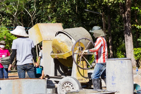 Lampang, thailand - 5. november 2016: unbekannte thailändische jugendliche in arbeitslager mixen beton mit mischmaschine am 5. november 2016 in lampang, thailand. — Stockfoto