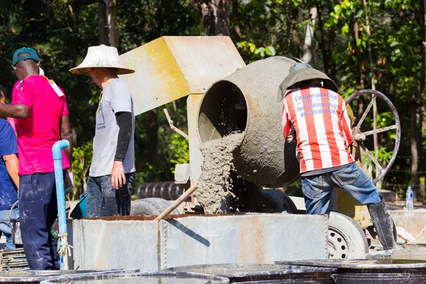 LAMPANG, THAILANDIA - 5 NOVEMBRE: adolescenti thailandesi non identificati nel campo di lavoro mescolando cemento e macchina miscelatrice il 5 novembre 2016 a Lampang, Thailandia . — Foto Stock