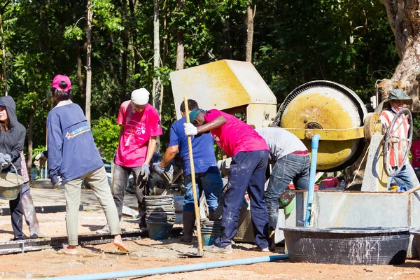 LAMPANG, THAILANDIA - 5 NOVEMBRE: adolescenti thailandesi non identificati nel campo di lavoro mescolando cemento e macchina miscelatrice il 5 novembre 2016 a Lampang, Thailandia . — Foto Stock