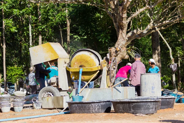 LAMPANG, THAILANDIA - 5 NOVEMBRE: adolescenti thailandesi non identificati nel campo di lavoro mescolando cemento e macchina miscelatrice il 5 novembre 2016 a Lampang, Thailandia . — Foto Stock