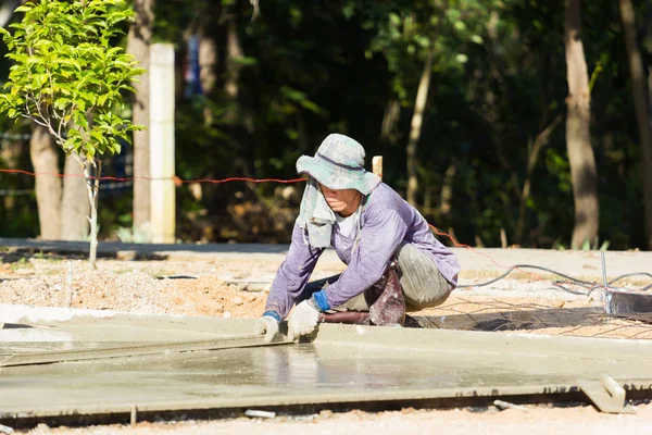 LAMPANG, THAILAND - NOVEMBRO 5: adolescentes tailandeses não identificados no campo de trabalho ajudam aldeões derramando concreto para fazer praça em 5 de novembro de 2016 em Lampang, Tailândia — Fotografia de Stock