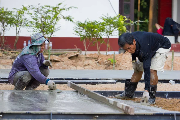 LAMPANG, THAÏLANDE - 5 NOVEMBRE : deux travailleurs thaïlandais non identifiés nivelant le béton avec une truelle le 5 novembre 2016 à Lampang, Thaïlande . — Photo