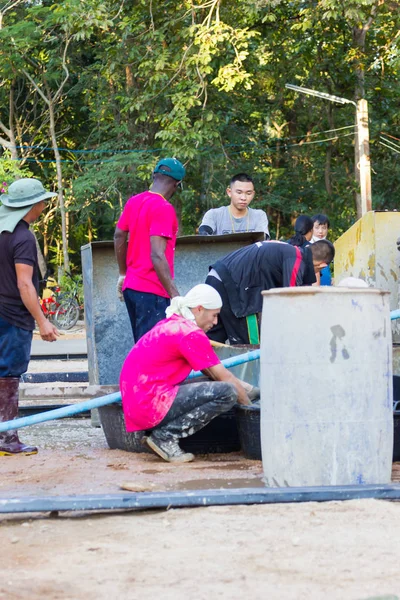 LAMPANG, THAÏLANDE - 5 NOVEMBRE : Des adolescents thaïs non identifiés dans un camp de travail transportant de l'eau pour mélanger du béton sur la place le 5 novembre 2016 à Lampang, Thaïlande . — Photo