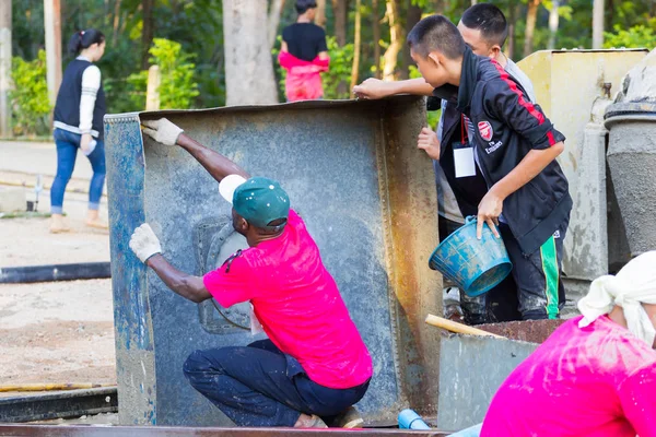 南邦府，泰国-11 月 5 日︰ 身份不明的非洲裔美国少年工作营清洗大盘子，混合的混凝土容器，在 2016 年 11 月 5 日在南邦府，泰国 — 图库照片