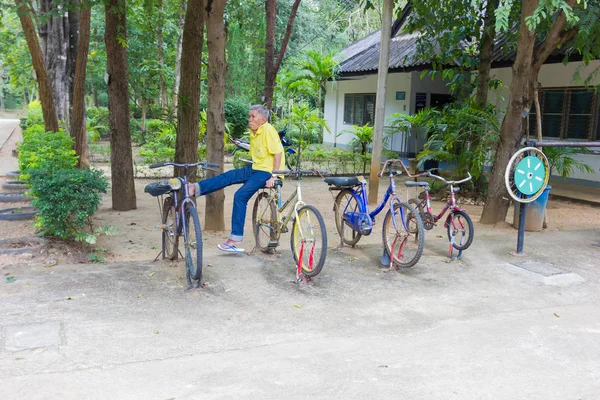 Lampang, Thailand - 5 November: oidentifierade thailändska gubbe sitter på dålig kondition cykeln 5 November 2016 i Lampang, Thailand. — Stockfoto