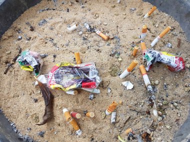 Chiang Rai, Tayland - 25 Kasım: Kirli kül tablası ile kum ve buruşuk sigaralık üzerinde 25 Kasım 2016 yılında Chiang rai, Tayland, kullanılan sigara izmariti